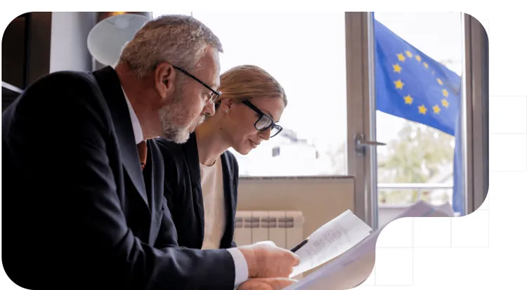Expertos analizando documentos de la normativa DAC7 para plataformas digitales con la bandera de la UE de fondo.